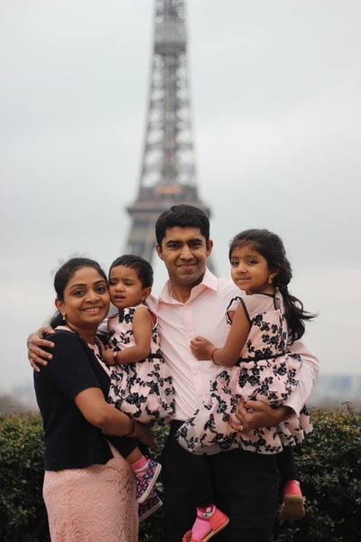 一家人在艾菲尔铁塔后面拍照